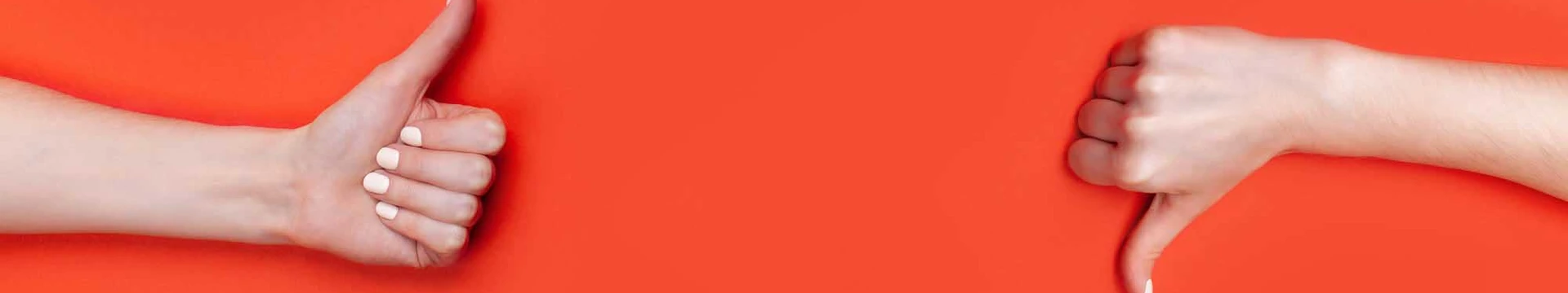 two hands on orange background, one thumb up, one thumb down
